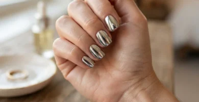 Close-up of silver mirror chrome nails in a short square shape on a realistic hand, liquid-metal finish in soft daylight