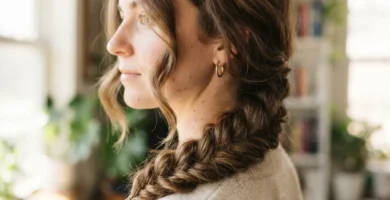 Soft pancaked fishtail braid draped over one shoulder on wavy brunette hair, a beginner-friendly viral braided hairstyle